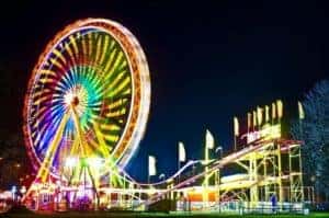 Ferris wheel and roller coaster in amusement park at night