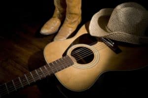 Country music setting with cowboy boots, cowboy hat, and guitar