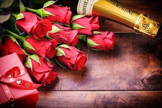Red roses, champagne bottle and chocolate box for romance package
