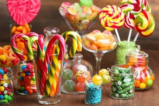 various types of candies in glass containers