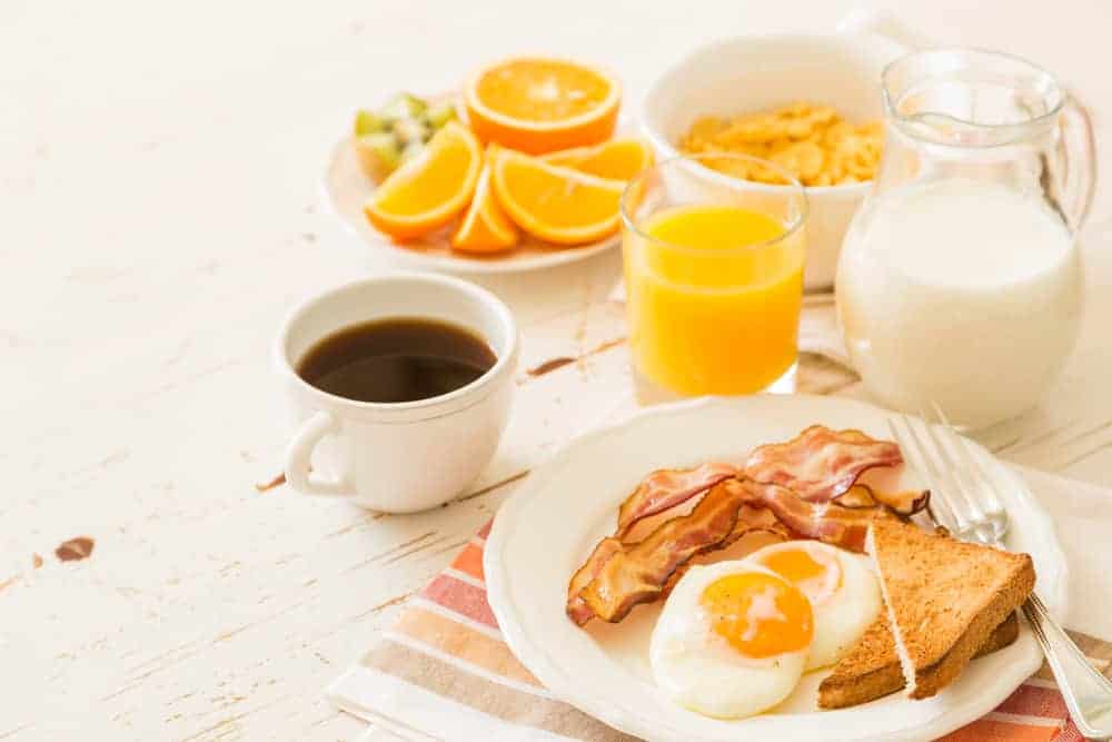 eggs, bacon, toast, cereal, orange, orange juice, milk, coffee